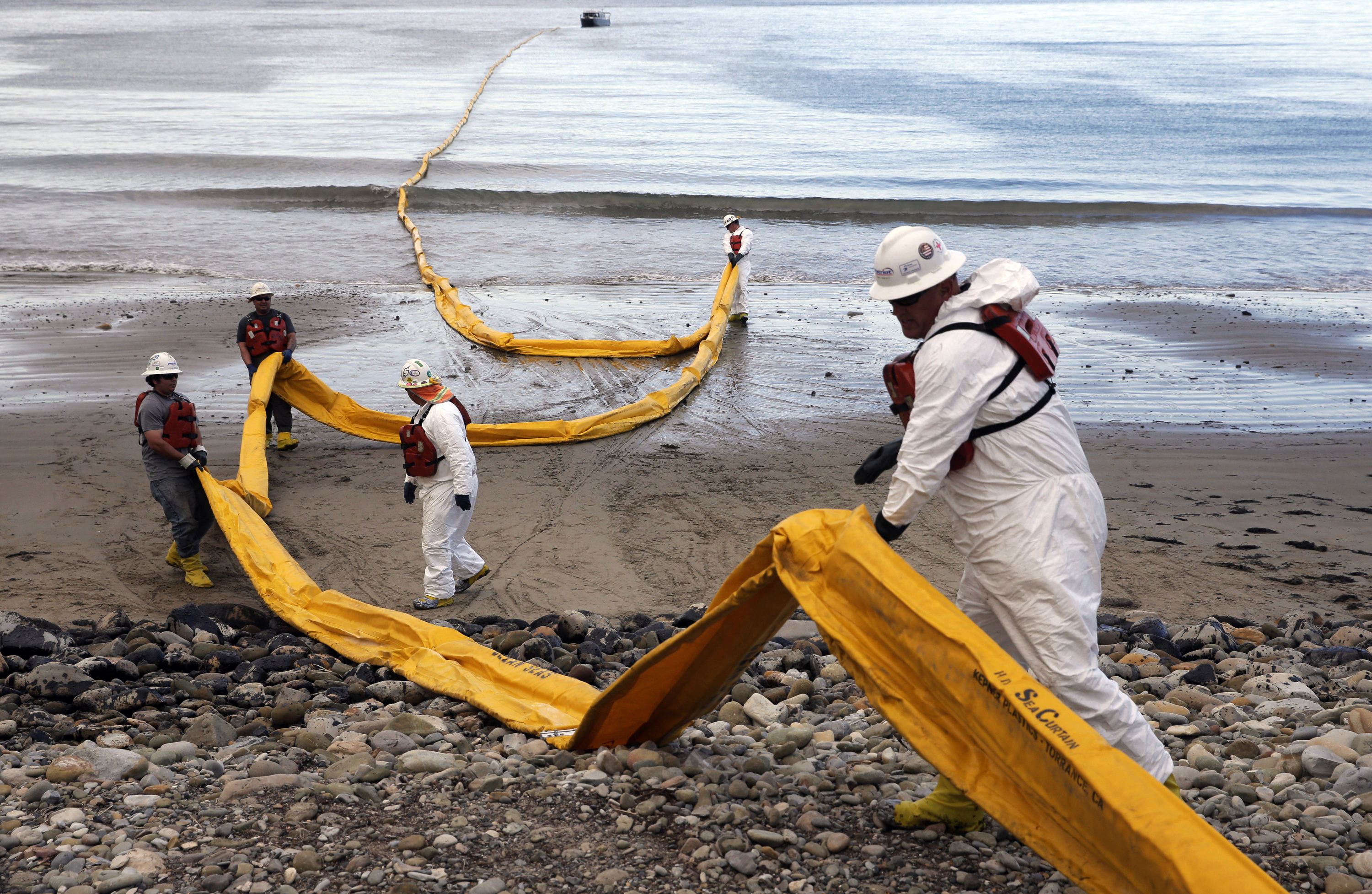 Workers in 2015 prepare an oil containment boom at Refugio State Beach, north of Goleta, California, two days after a ruptured pipeline created the largest coastal oil spill in California in 25 years.